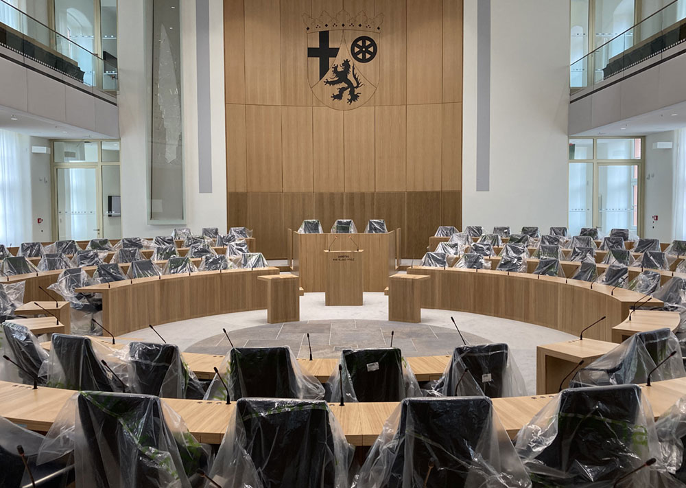 Der Landtag in Mainz, das historisch bedeutende „Deutschhaus“, wurde zwischen 2018 und 2021 generalsaniert. Die Lüftung wurde so ausgelegt, dass die beste Kategorie der „Indoor Air Quality“ erreicht wird. Ein Videobeitrag des SWR zeigt die Baustelle des Landtags und die dortige Lüftungsanlage. 